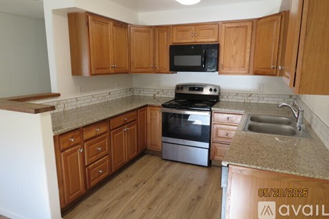A kitchen with wooden cabinets and a granite countertop.