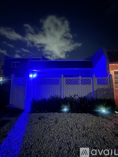 A house is illuminated with blue lights at night.