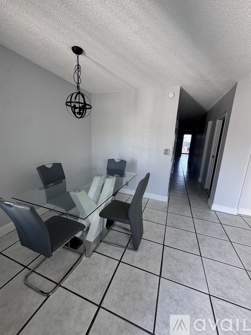 A dining room with a glass table and chairs.