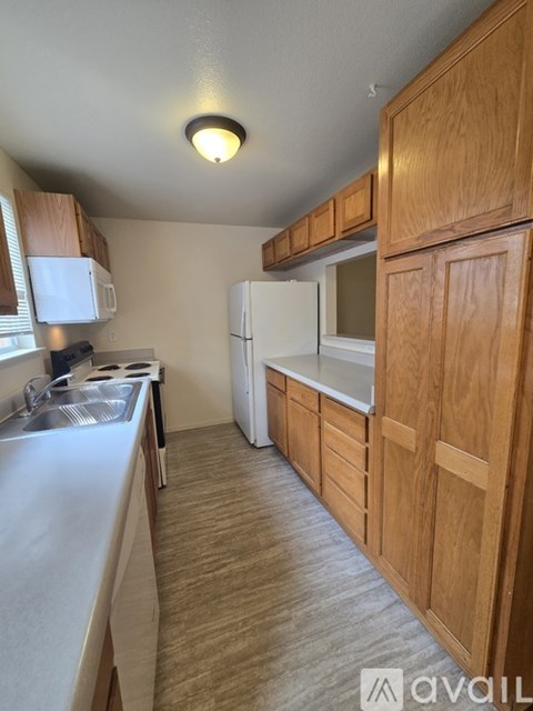 A kitchen with wooden cabinets and a white fridge.