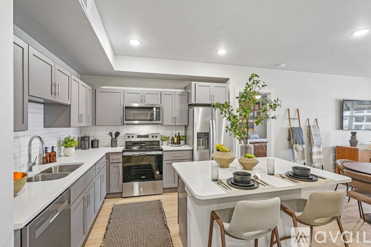 A modern kitchen with a dining table set for two.
