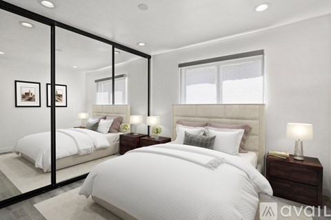 A bedroom with a large bed and a mirrored wall.