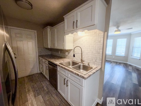 A kitchen with white cabinets and a tiled backsplash.