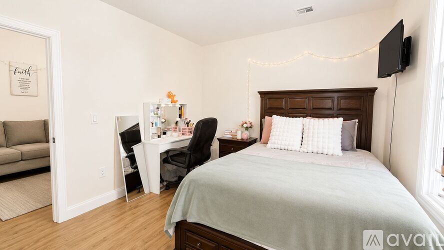 A bedroom with a bed, desk, and chair.