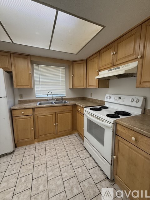 A kitchen with white appliances and wooden cabinets.