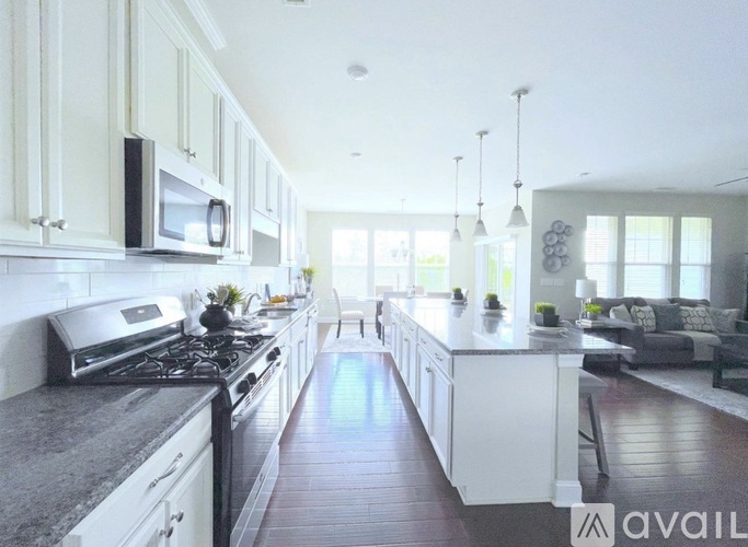 A modern kitchen with white cabinets and a dark countertop.