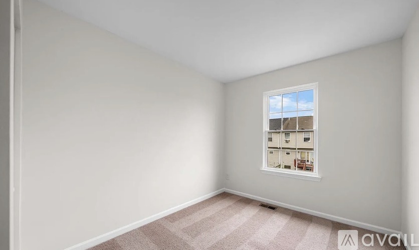 A room with a window showing a view of a building outside.