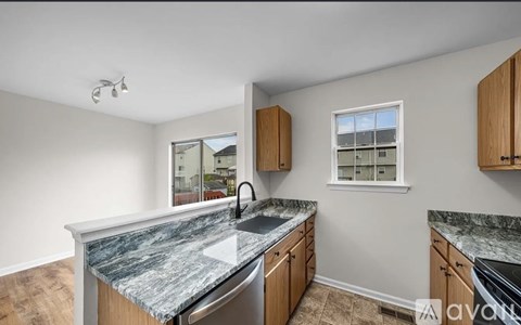 A kitchen with granite countertops and wooden cabinets.