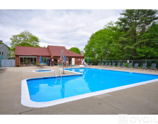 A large outdoor swimming pool with a red building in the background.