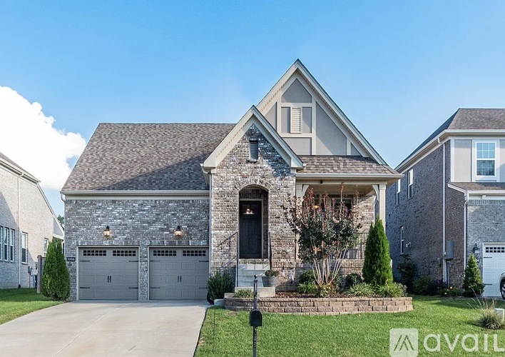 A house with a stone facade and a large front yard.