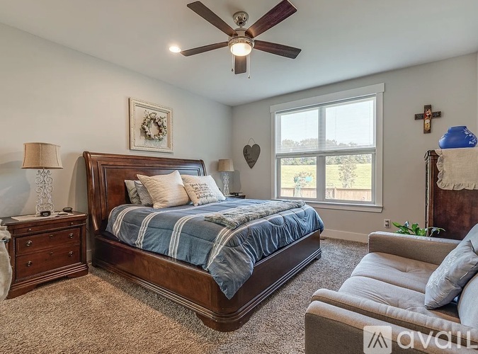 A bedroom with a large bed and a ceiling fan.