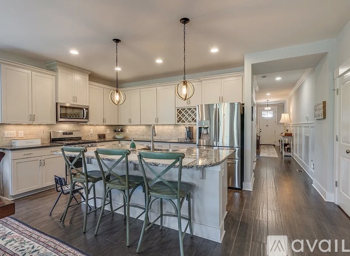 A kitchen with white cabinets and a granite countertop.