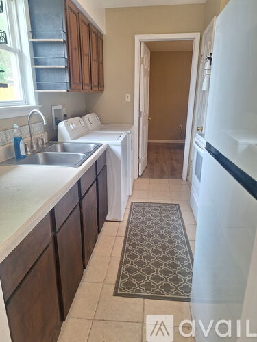 A kitchen with a white fridge and brown cabinets.