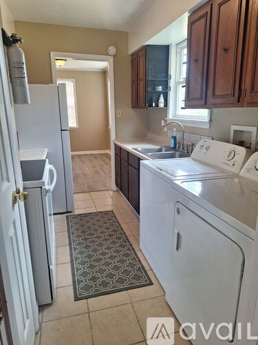 A kitchen with white appliances and brown cabinets.