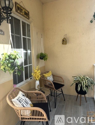 A patio with a chair and a table with a vase of flowers on it.