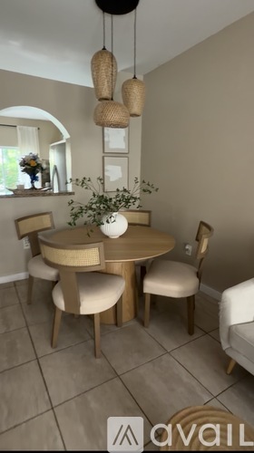 A dining room with a round table and chairs.
