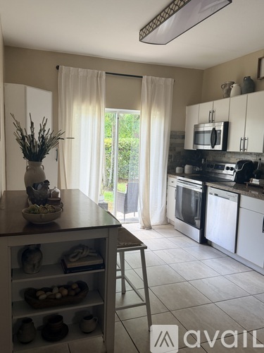 A kitchen with white cabinets and a wooden island.