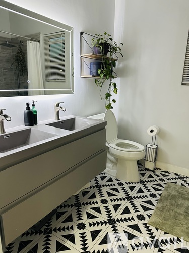 A bathroom with a black and white tiled floor.