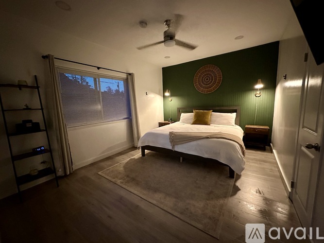 A bedroom with a bed, a ceiling fan, and a rug.