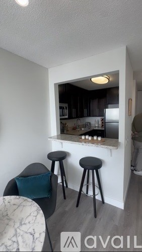 A kitchen area with a bar stool and a counter.