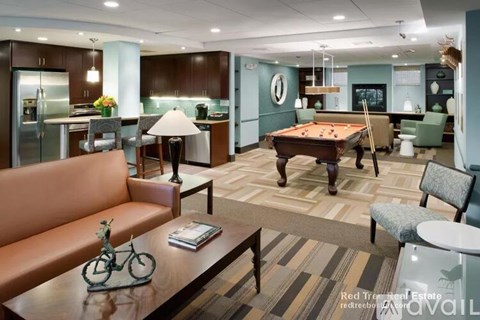 A living room with a pool table and a couch.