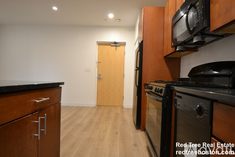 A kitchen with wooden cabinets and black appliances.