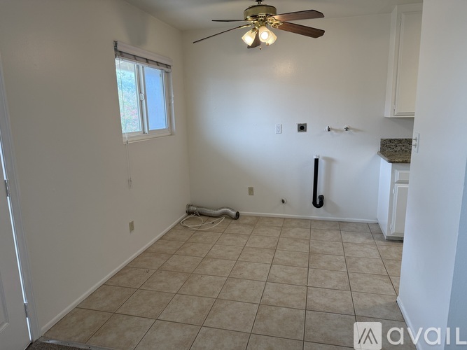 A room with a ceiling fan and tile flooring.
