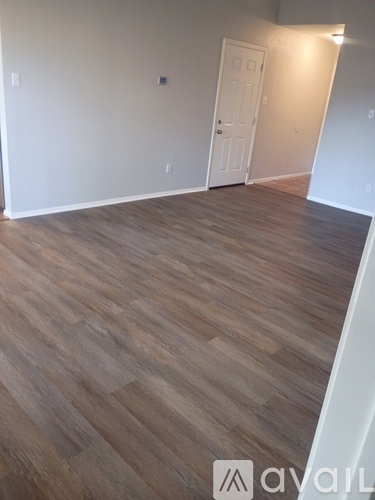 A room with wooden flooring and a white door.