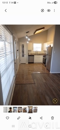 A modern kitchen with a refrigerator, sink, and cabinets.