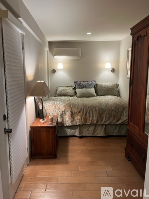 A bedroom with a bed, nightstand, and lamp.