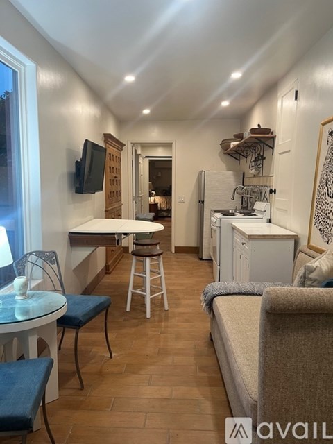 A kitchen area with a table and chairs.