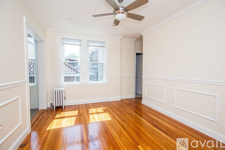 A room with wooden floors and a ceiling fan.