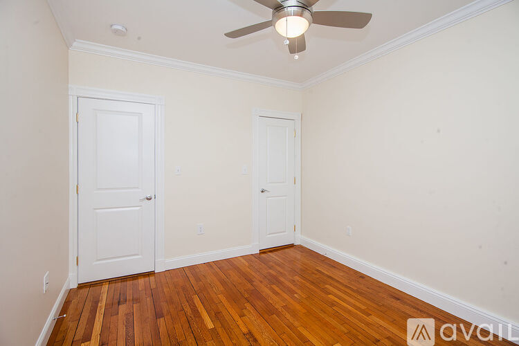 A room with a ceiling fan and two doors.