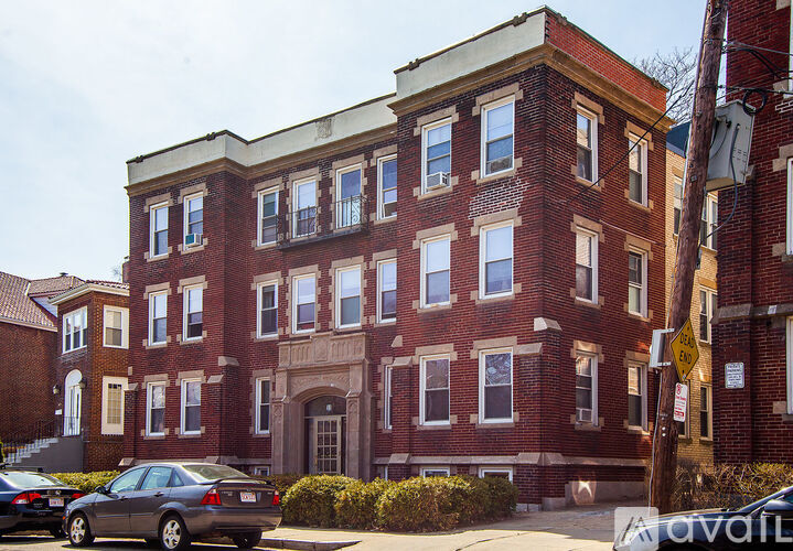 A brick building with a car parked in front.