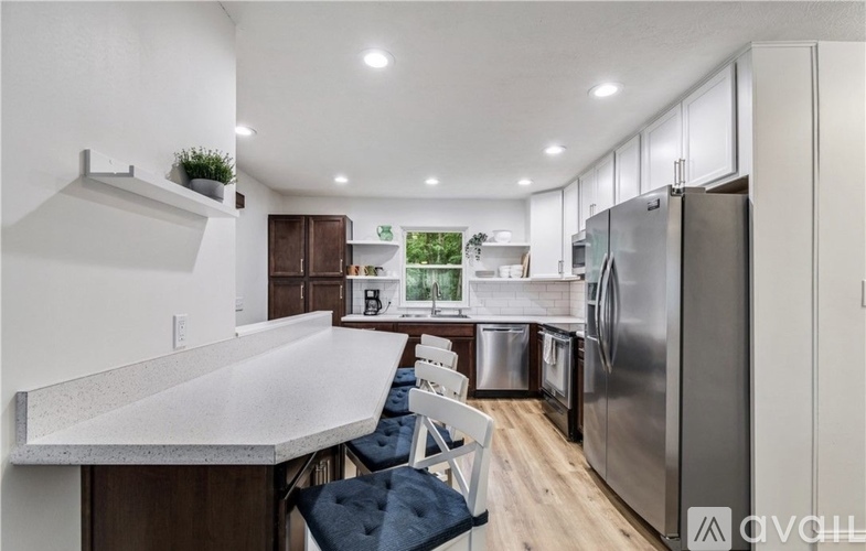 A modern kitchen with a large island and stainless steel appliances.