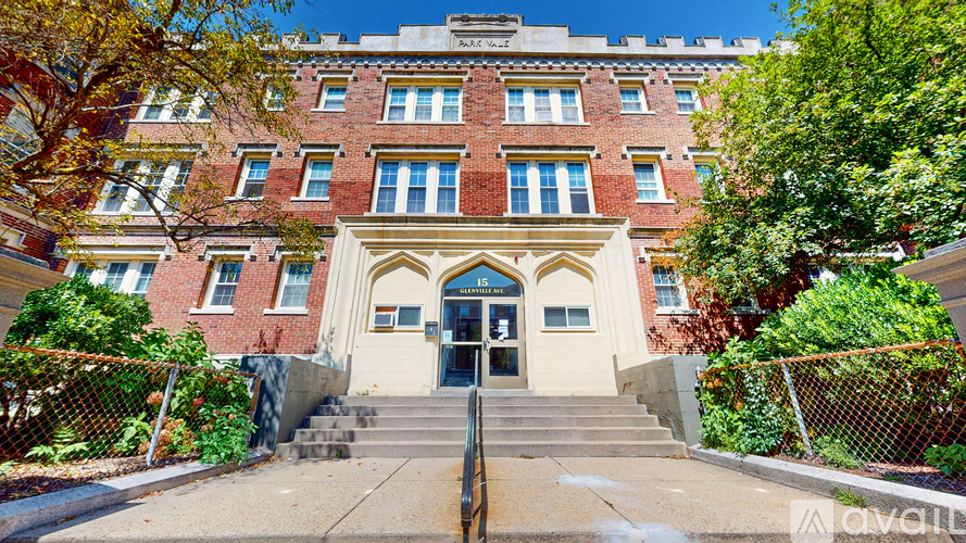 A red brick building with a white entrance and steps leading up to it.