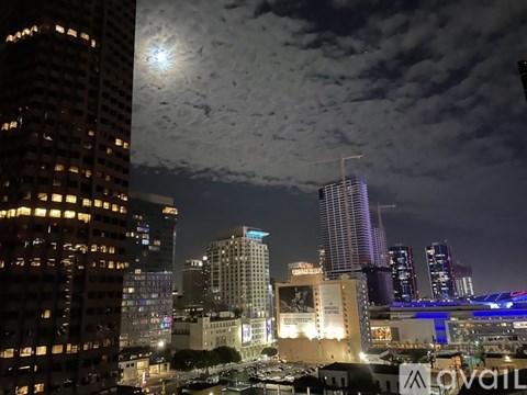 A cityscape at night with a full moon in the sky.