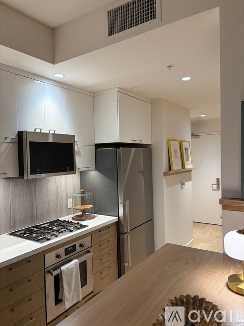 A modern kitchen with wooden cabinets and stainless steel appliances.