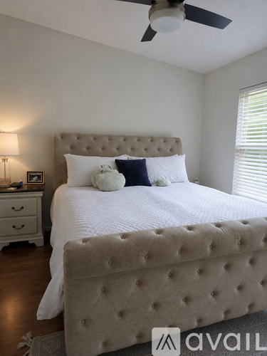 A bedroom with a large bed and a ceiling fan.