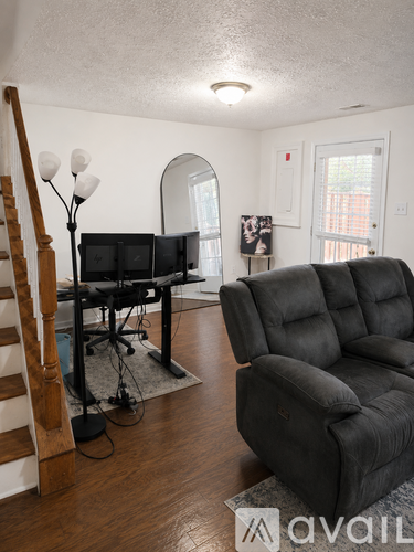 A living room with a black sofa and a TV stand.