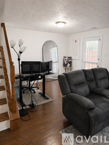 A living room with a black sofa and a TV stand.