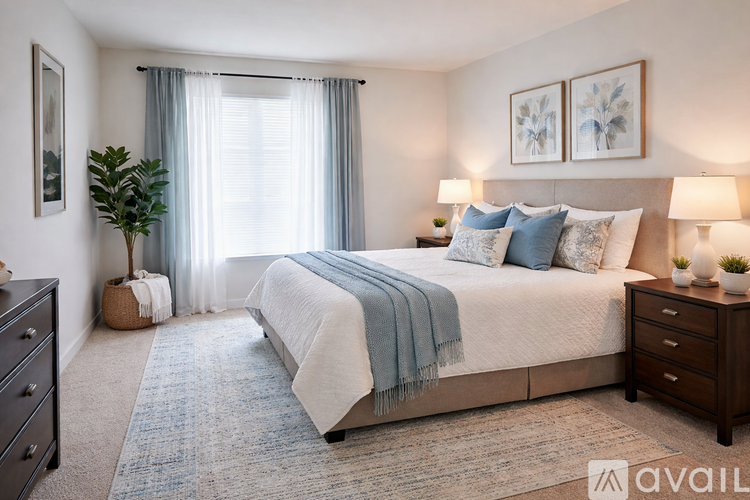 A bedroom with a large bed, a nightstand, and a plant.