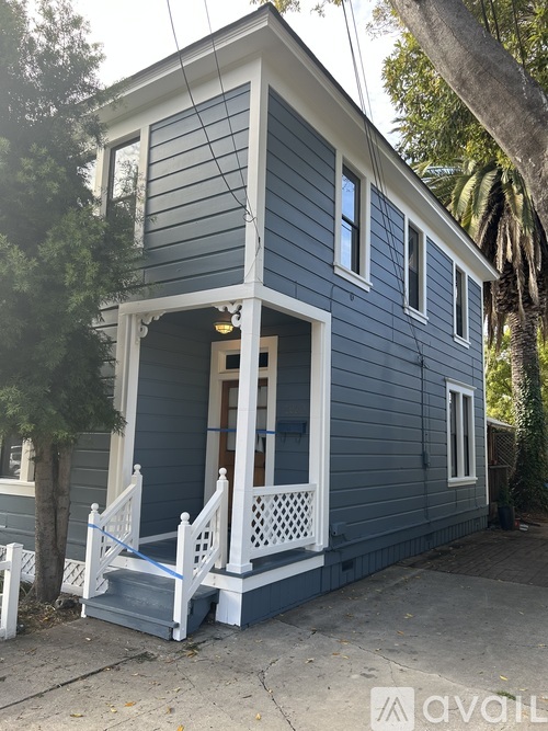 A blue house with a porch and a white railing.