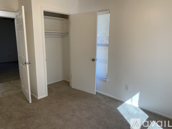 A room with a white door and a carpeted floor.