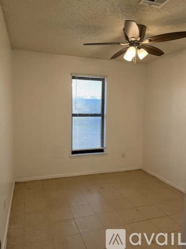 A room with a ceiling fan and a window.