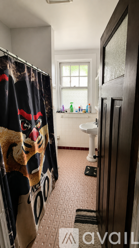 A bathroom with a shower curtain that has a tiger on it.