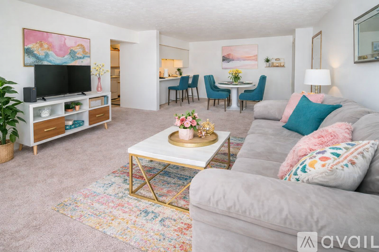 A living room with a grey couch, a coffee table, and a television.