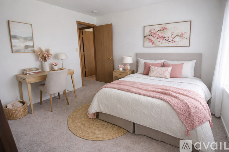 A bedroom with a large bed and a desk with a chair.