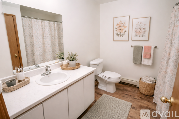 A bathroom with a white sink, toilet, and a shower curtain.
