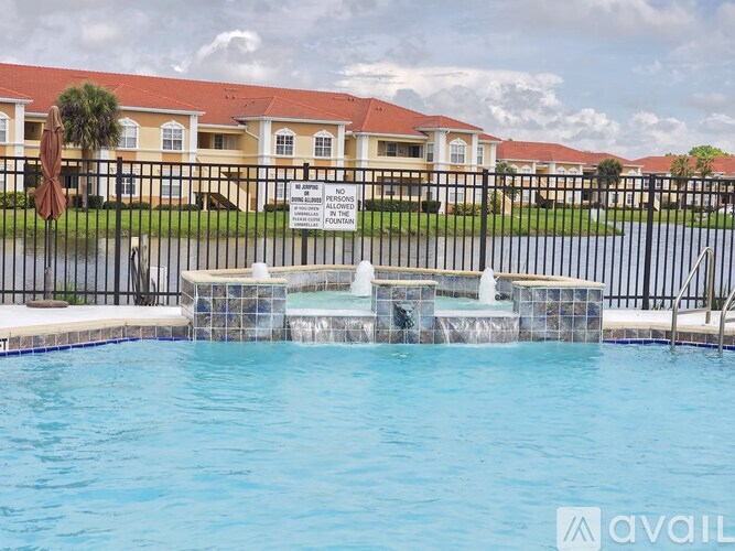 A pool with a sign that says "NO PLAYING" in front of a building.